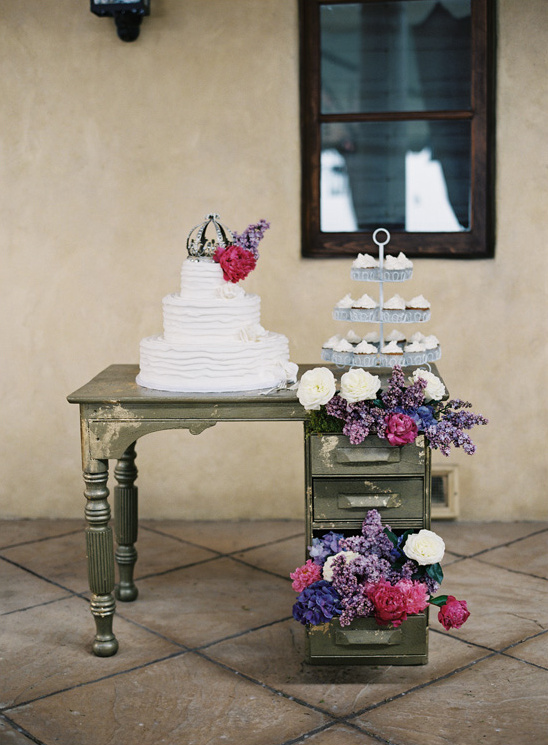 put a cake on a desk open the drawers and put florals in it