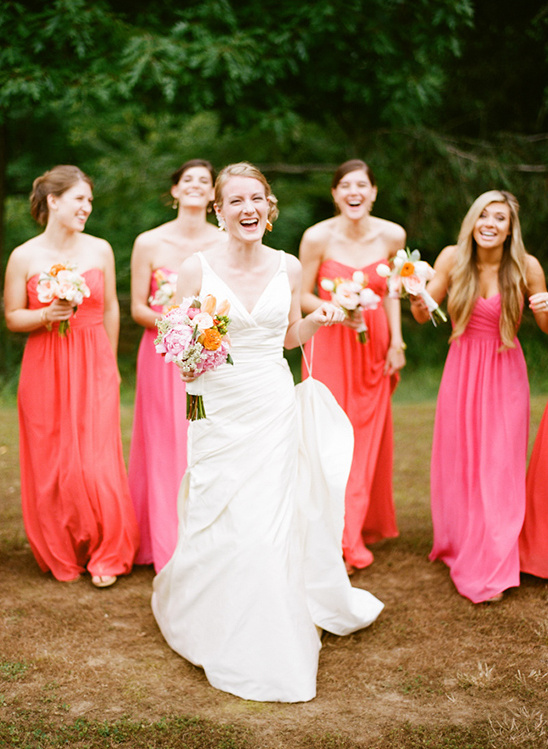 Happy bride surrounded by bridesmaids in colorful dresses