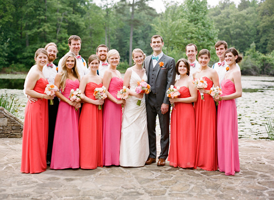 Wedding party posing together by a lake, cheerful and joyful