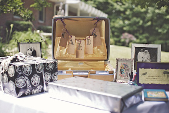 Wedding reception with a card box, gifts, and framed pictures
