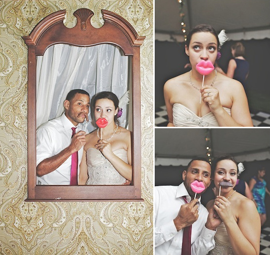 Playful bride and groom posing with props in a mirror photo booth