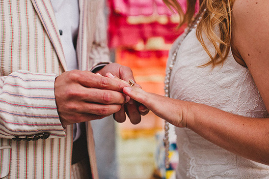 Man putting a wedding ring on woman's finger during a ceremony