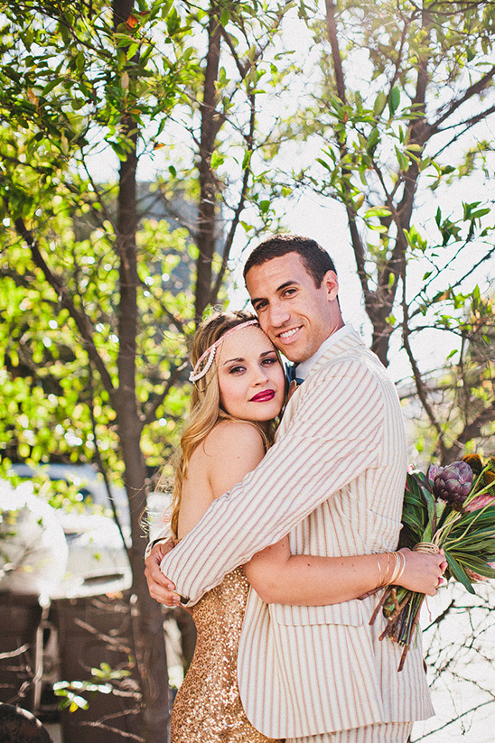Smiling couple embracing during a Gatsby themed wedding outdoors