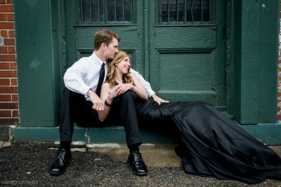 Couple dressed elegantly in front of green doors, looking at each other