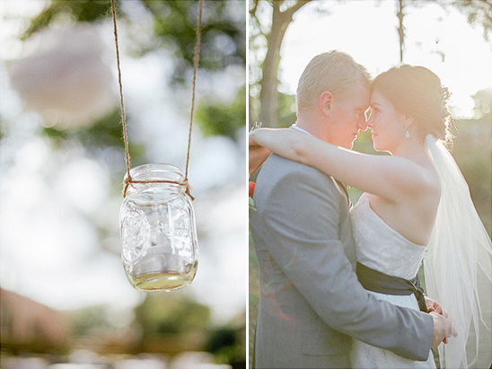 Bride and groom embrace with hanging jar decoration