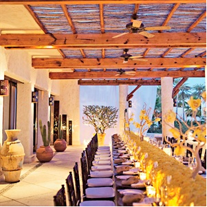 Elegant outdoor dining setting with long table and ceiling fans