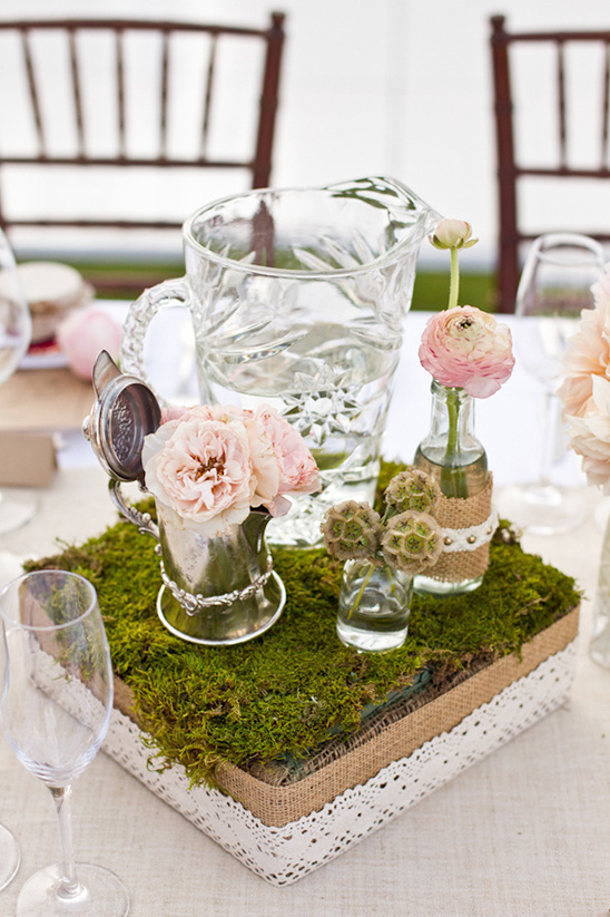Elegant floral centerpiece on a moss and burlap table decoration