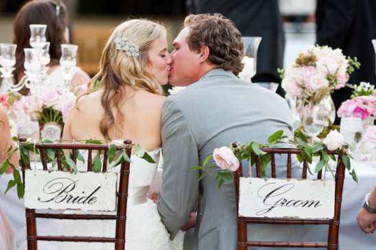 Bride and groom share a kiss at a beautifully decorated wedding reception