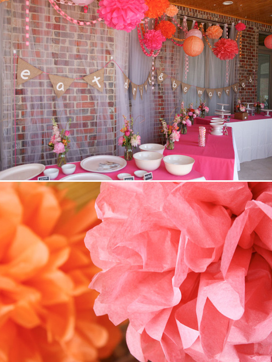 Festive party decorations with colorful paper flowers and pink tablecloth