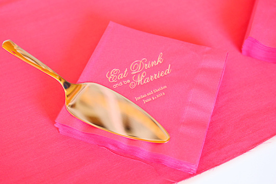 Gold cake server on pink Eat Drink and be Married napkins