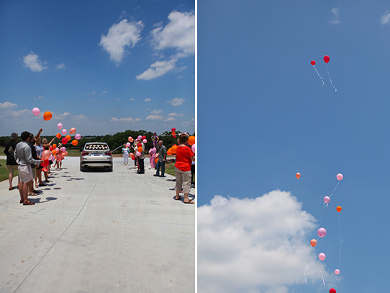 People releasing balloons in the air on a sunny day near a car