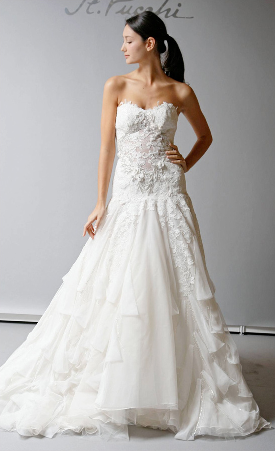 Elegant strapless white wedding dress with lace detailing and tiers