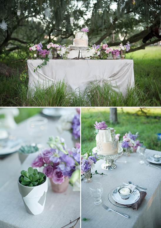 Elegant outdoor wedding cake table with floral decor and lush greenery