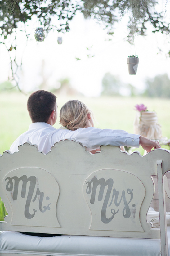 Couple seated on bench with Mr and Mrs at a wedding