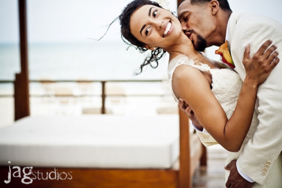 Happy couple kissing on their wedding day, beach background