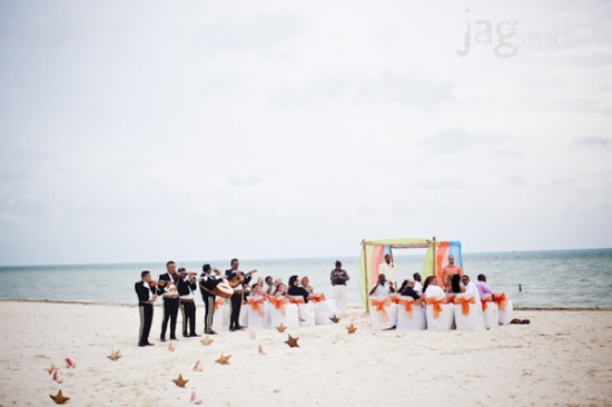 Beach wedding with mariachi band playing by the ocean