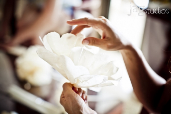 Woman crafting a paper flower with delicate hand movements