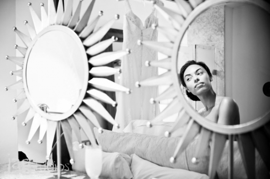 Woman gazing in a decorative mirror, black and white artistic portrait