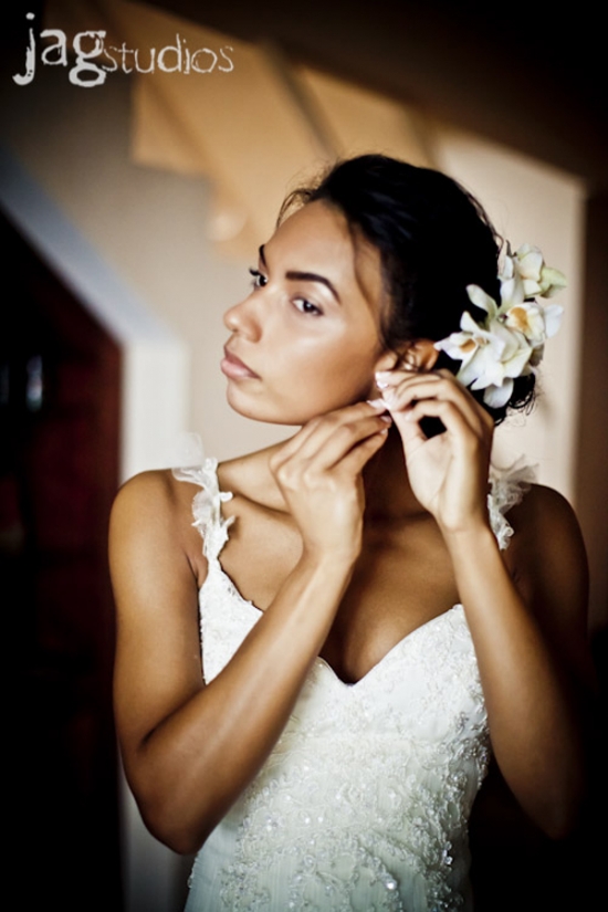 Bride in white dress putting on earrings before the wedding