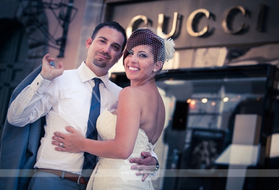 Happy couple posing in front of the Gucci store after wedding ceremony