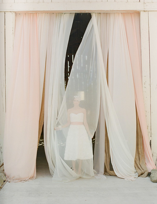 Bride in white dress, pastel curtains