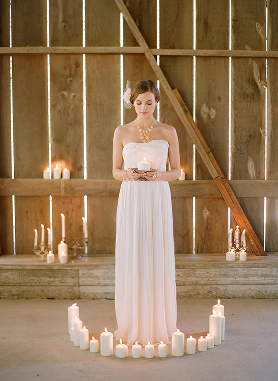 Woman in white dress holding candle, candles arranged in circle