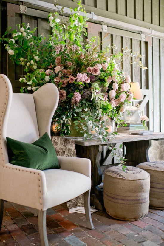 Elegant cream chair with green pillow near floral arrangement