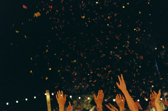 Colorful confetti falls on raised hands