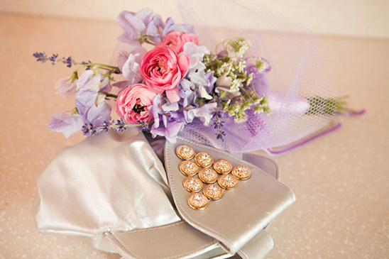 Pastel flower bouquet rests on elegant silver clutch