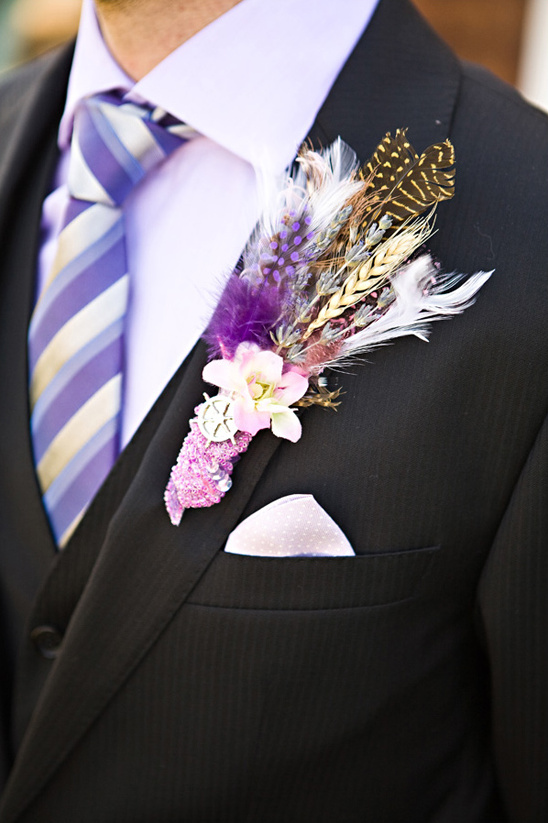 Purple and brown feather boutonniere on a suit jacket