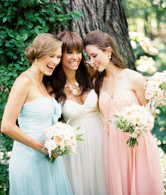 Happy bridesmaids in pastel gowns at wedding