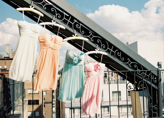 Pastel bridesmaid dresses hanging outdoors