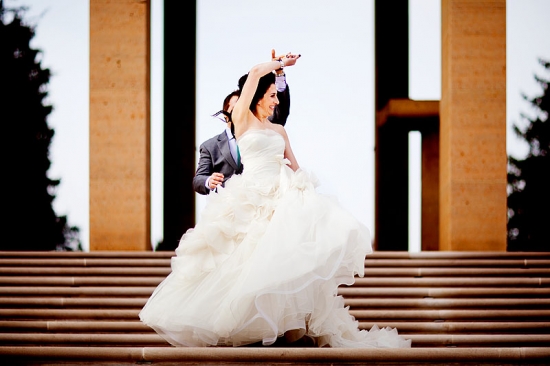 Happy bride and groom ascend stairs in wedding attire