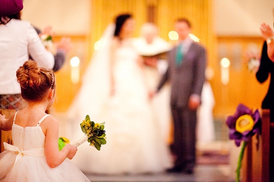 Flower girl at wedding ceremony holding bouquet