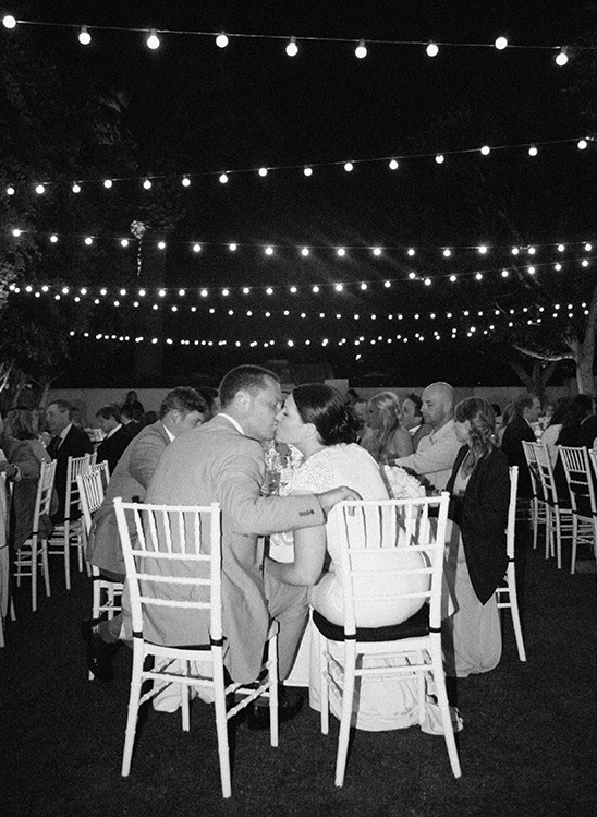 Romantic couple kissing at night wedding reception