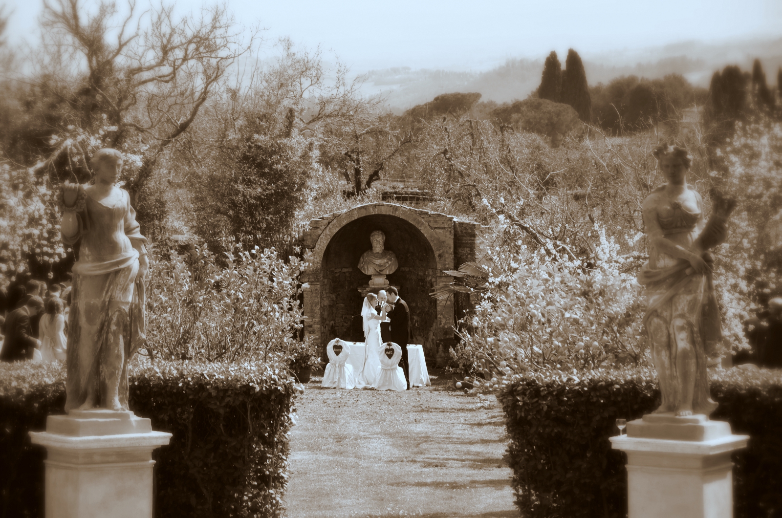 Garden wedding sepia with statues and stone archway