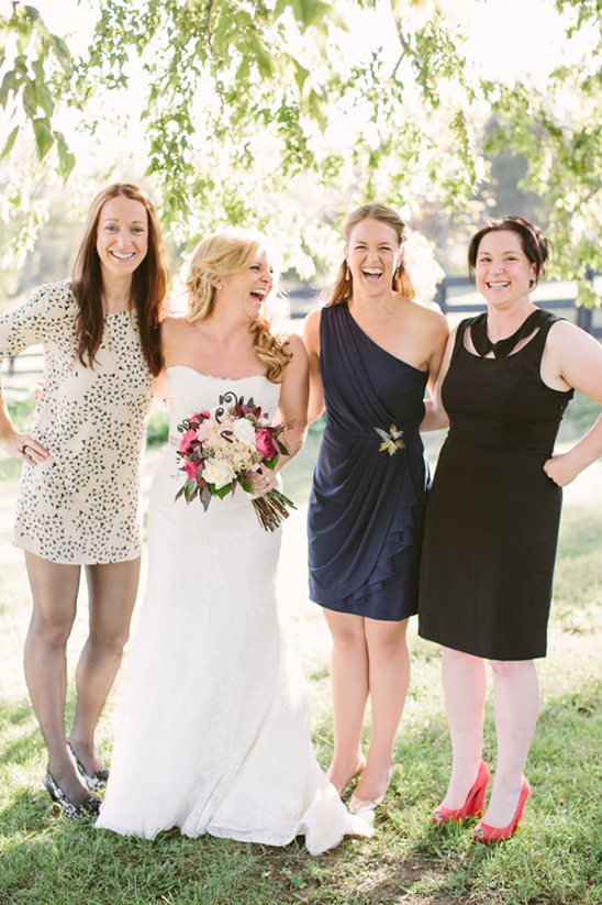 Bride and bridesmaids laughing outdoors on wedding day