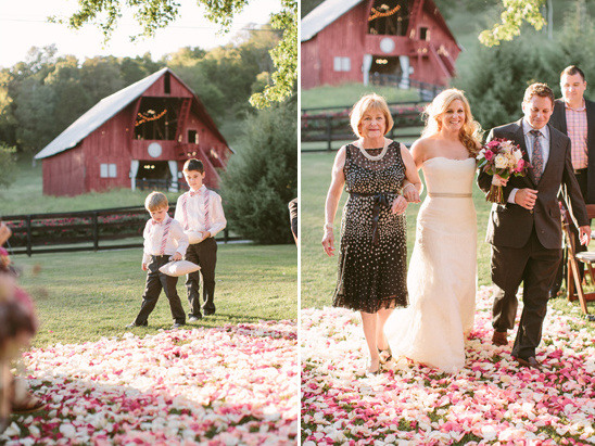 Bride escorted at rustic barn wedding with rose petal aisle
