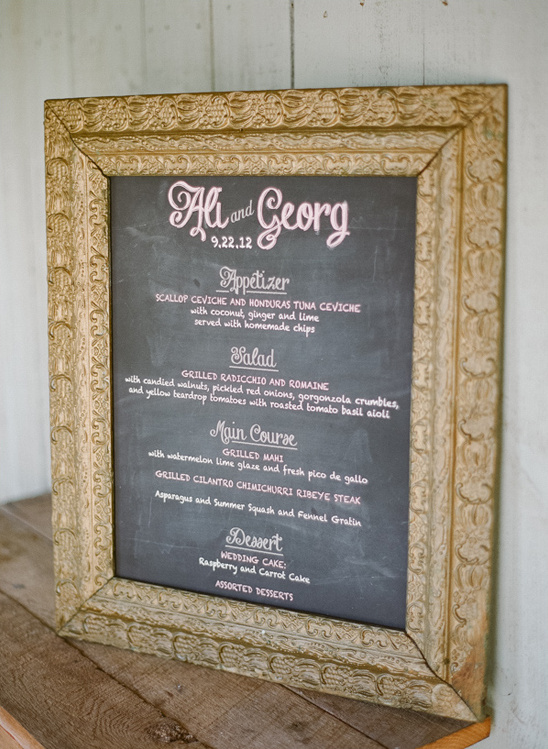 Ali and Georgs wedding menu on a chalk board in frame