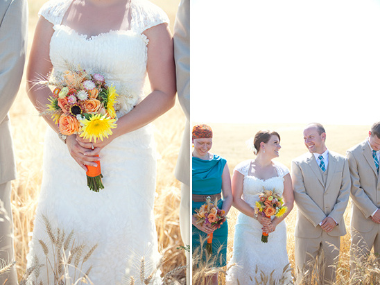 Bride in lace dress holding colorful bouquet in wheat field