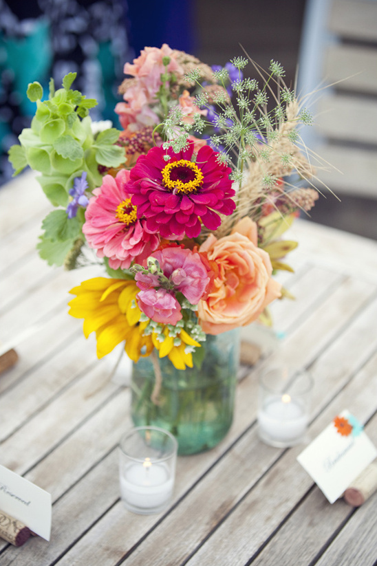 Vibrant flowers in mason jar wedding table decor