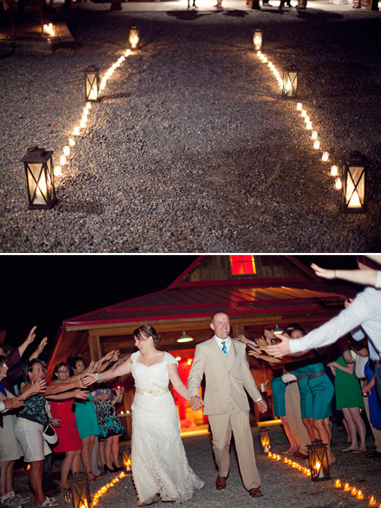 Bride and groom walk a lantern lit wedding path