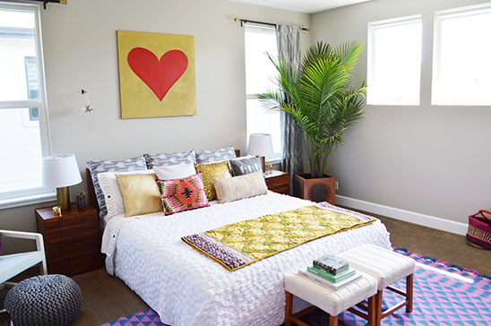 Cozy bedroom with gold heart art and colorful bedding