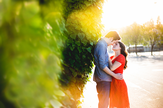Romantic couple embracing near green foliage