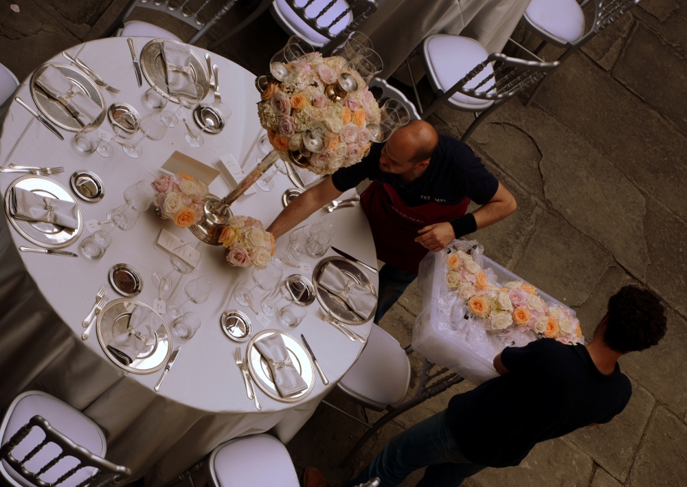 Floral designers arranging elegant table setting for event