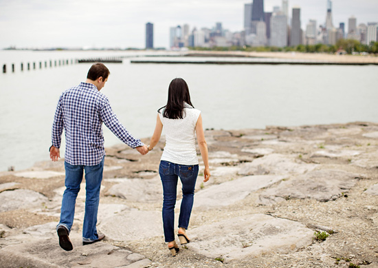 Couple holding hands, walking toward Chicago skyline