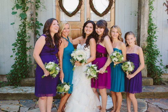 Bride with bridesmaids in colorful dresses outdoors