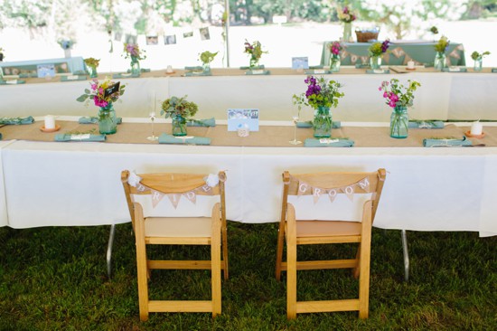 Rustic wedding head table with bride and groom chairs
