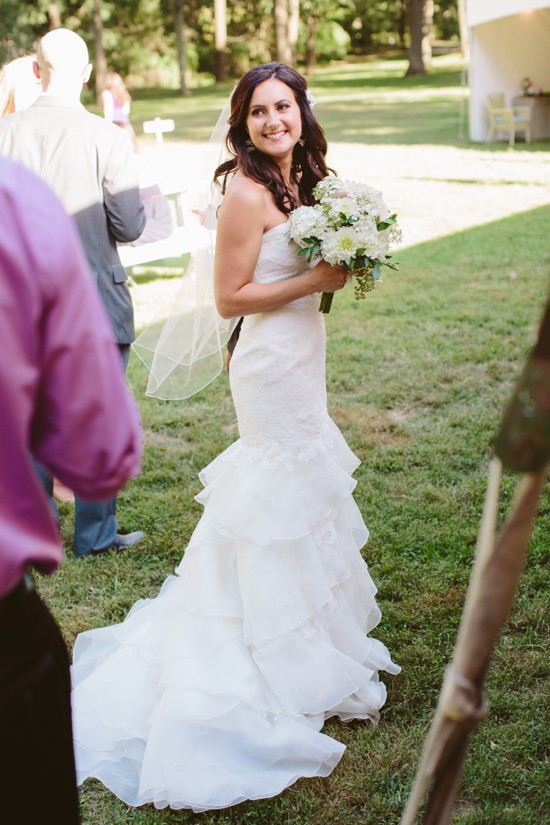 Beautiful bride in her wedding dress smiles outdoors