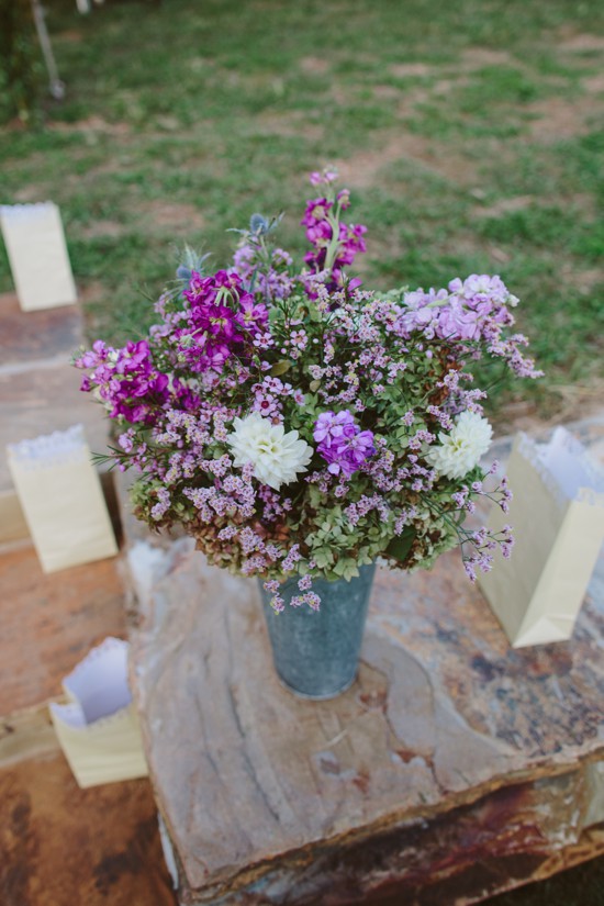 Purple and white flower arrangement in a tin vase